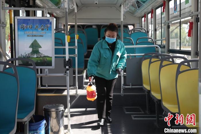 工作人員正在對(duì)公交車(chē)進(jìn)行消殺?！∮诰?攝