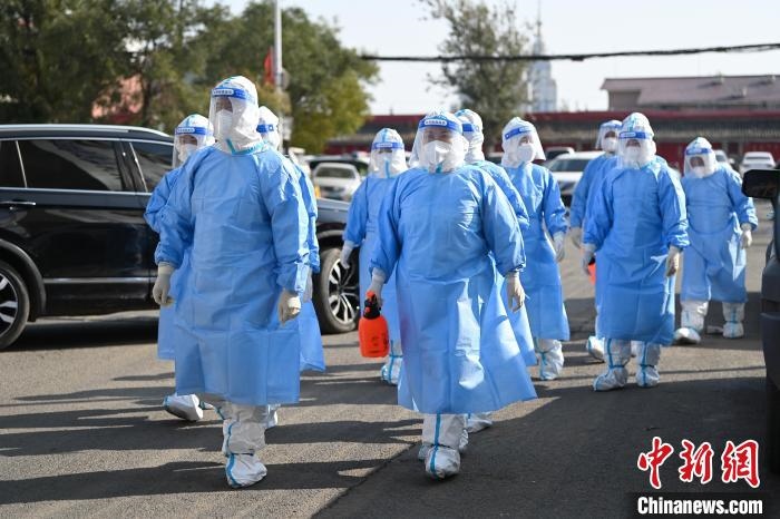 圖為醫(yī)務(wù)人員在封閉小區(qū)做防控工作?！⑽娜A 攝