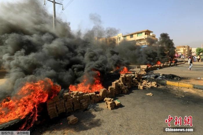 當(dāng)?shù)貢r間10月25日，蘇丹局勢發(fā)生突變，過渡政府總理被“綁架”，政府部長被軍方抓捕，國家進入緊急狀態(tài)，大量民眾走上街頭對軍方行動進行抗議，已有7人在抗議活動中死亡，140人受傷。圖為抗議活動中燃燒的輪胎。