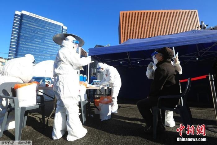 資料圖：韓國首爾，醫(yī)務人員對市民進行新冠病毒檢測。