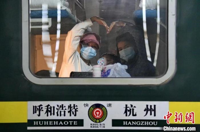 圖為登上轉(zhuǎn)運(yùn)火車的游客向額濟(jì)納比心?！⊥趵?攝