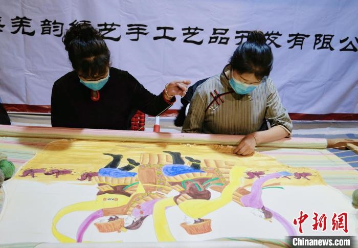 圖為皮繡藝人在市集上“秀”指尖技藝?！●R銘言 攝