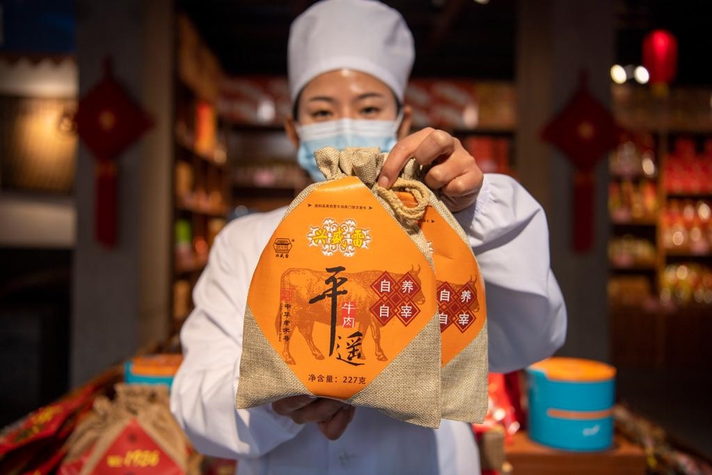 1月27日，在平遙古城南大街的一家平遙牛肉店內(nèi)，工作人員展示一款牛肉產(chǎn)品。新華社記者 楊晨光 攝