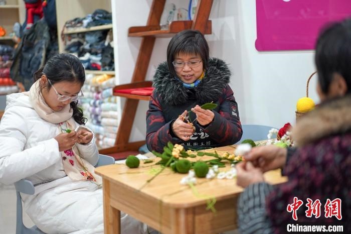 文創(chuàng)工作室的姐妹們正在鉤織月桂葉片。　古良駒 攝