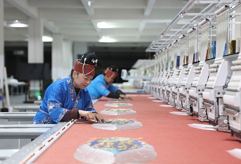 2023年2月13日，貴州省黔東南苗族侗族自治州施秉縣工業(yè)園區(qū)，工人在機(jī)繡車間作業(yè)。