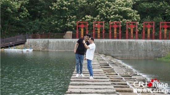 “一帶一路”國際青年走進信陽羅山 看“紅”“綠”資源助力鄉(xiāng)村未來_fororder_國際青年在九龍河上拍照記錄 攝影 賈親親.JPG