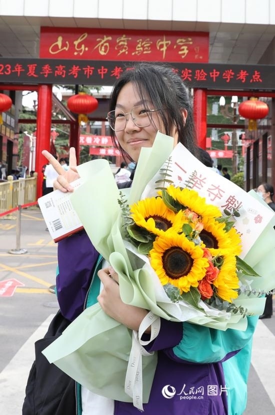 6月7日高考首日，山東67萬考生走進考場，拼搏逐夢。在山東省實驗中學考點，考生進考場前手捧向日葵花拍照留念，寓意“一舉奪魁”。人民網記者 劉祺攝