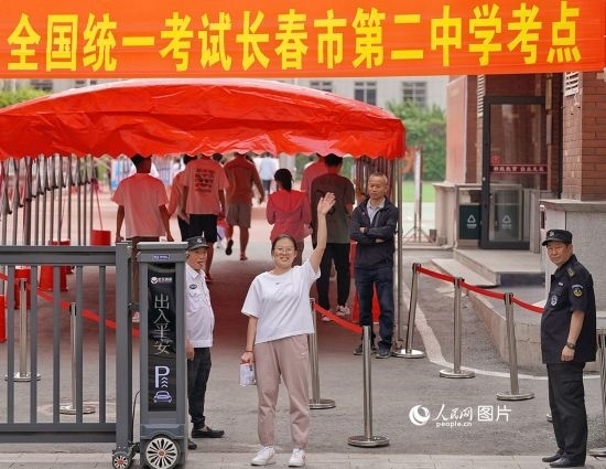 6月7日，在長春市第二中學考點，一名考生信心滿滿進入考場，并與家長揮手致意。人民網記者 李洋攝