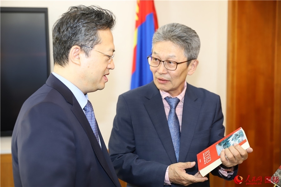 其米德策耶（右一）向李峙介紹翻譯成果。人民網(wǎng)記者 霍文攝