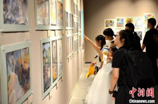 圖為家長帶著孩子參觀展覽。呂明 攝