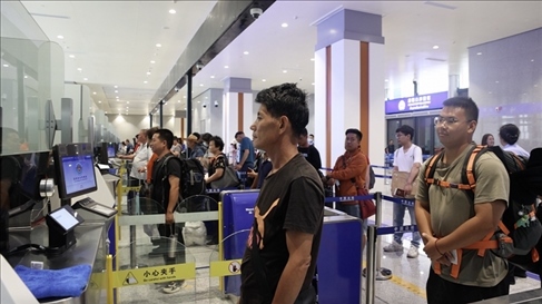 6月13日，乘坐中老鐵路國際旅客列車的旅客在磨憨邊檢大廳排隊(duì)候檢。李揚(yáng) 攝