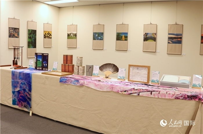 現(xiàn)場展出的馮學(xué)敏攝影作品與湖州市特色工藝品。（人民網(wǎng) 許可攝）