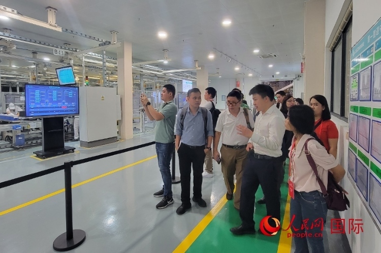 廣汽埃安工作人員向外媒記者進行介紹。人民網(wǎng) 寧玉瑛攝