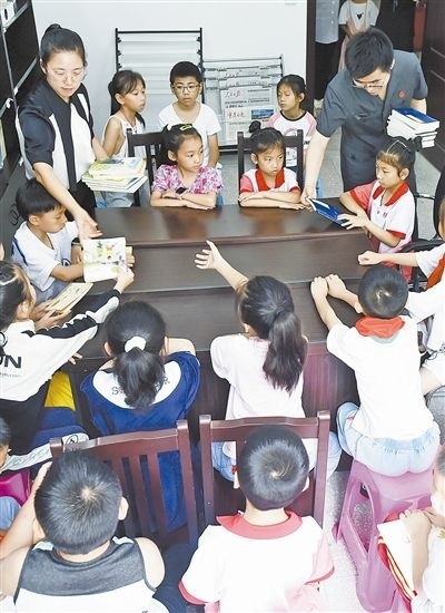  圖④：法院干警為留守兒童發(fā)放暑假讀物。