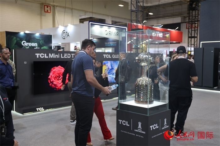 參觀者在TCL展臺前觀看南美解放者杯獎杯，據(jù)介紹，TCL是南美解放者杯（2023—2026賽季）全球官方合作伙伴。（人民網(wǎng)記者 時元皓攝）