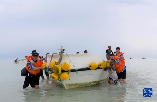 7月21日，中國海軍“和平方舟”號(hào)醫(yī)院船醫(yī)護(hù)人員涉水登島，前往基里巴斯一診療點(diǎn)。新華社記者 黎云 攝