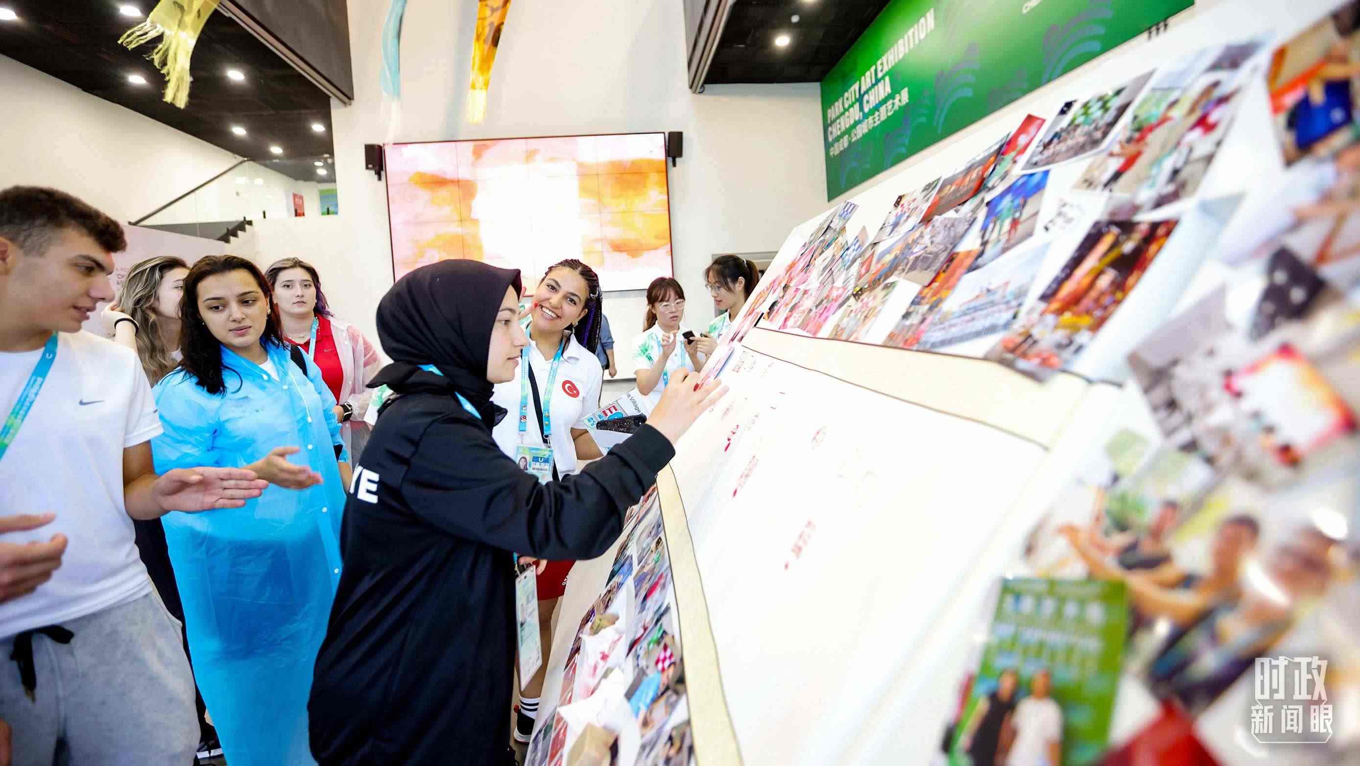 各國青年運動員正在參觀成都大運村內的“雪山下的公園城市，煙火里的幸福成都”主題藝術展。（總臺央視記者魏幫軍拍攝）
