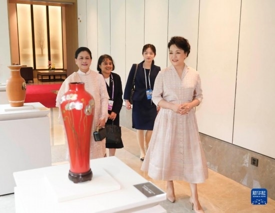 7月27日下午，國家主席習(xí)近平夫人彭麗媛在四川成都會(huì)見陪同印度尼西亞總統(tǒng)佐科來華出席第31屆世界大學(xué)生夏季運(yùn)動(dòng)會(huì)開幕式并訪華的總統(tǒng)夫人伊莉亞娜。這是彭麗媛和伊莉亞娜欣賞成都特色非遺工藝品。新華社記者 丁林 攝