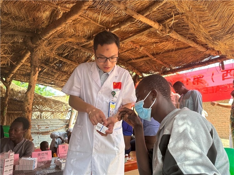 圖為南昌大學(xué)第一附屬醫(yī)院病理科主治醫(yī)師張振東為村民解說(shuō)藥品使用方法。中國(guó)駐乍得醫(yī)療隊(duì)供圖