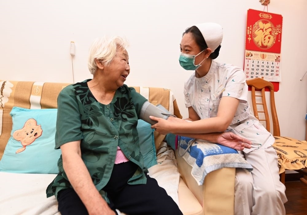 河北廊坊三河市燕達金色年華健康養(yǎng)護中心醫(yī)務(wù)人員為入住老人測量血壓（2023年7月20日攝）。新華社記者 朱旭東 攝