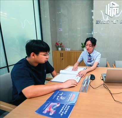 在杭州市臨安區(qū)政務(wù)服務(wù)中心的“為企服務(wù)中心”，黨員志愿者（右）解答企業(yè)主的疑問（2023年7月7日攝）。徐昱攝/本刊