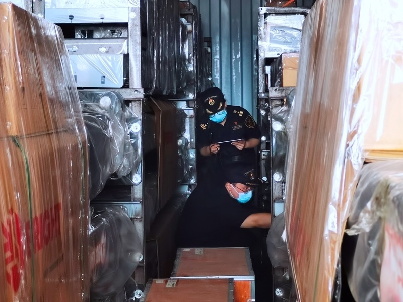 關(guān)員利用工業(yè)內(nèi)窺鏡在集裝箱內(nèi)進行查驗。人民網(wǎng)記者 栗翹楚攝