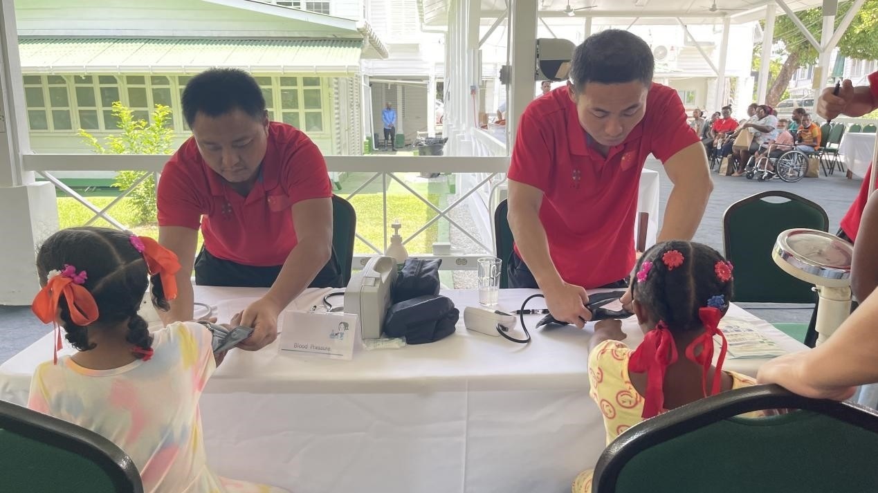 醫(yī)療隊(duì)員為福利院兒童進(jìn)行檢查。第18期援圭亞那醫(yī)療隊(duì)供圖
