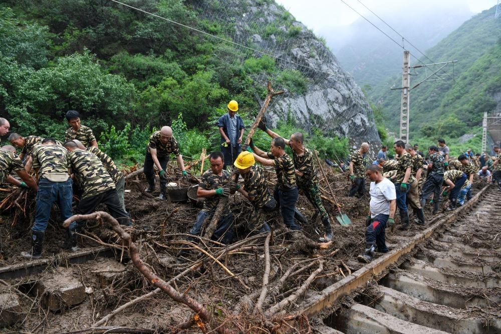 8月1日，在北京市門頭溝區(qū)水峪嘴村附近一段被阻斷的鐵路線上，中鐵六局工作人員在清理軌道上的雜物，全力恢復交通。新華社記者 鞠煥宗 攝