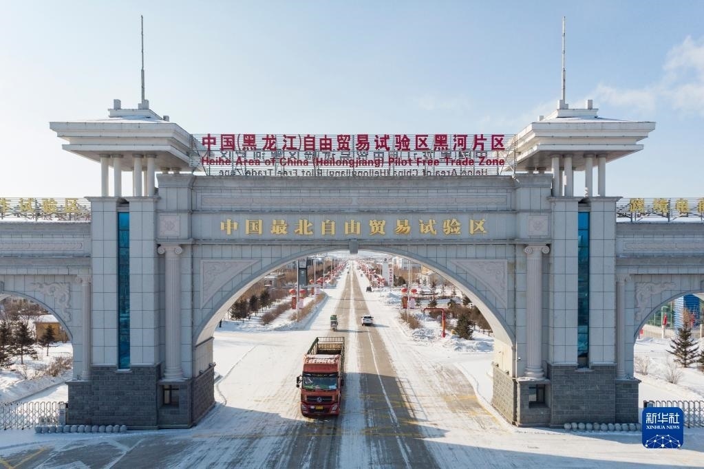 2月11日，車輛駛出中國(guó)（黑龍江）自由貿(mào)易試驗(yàn)區(qū)黑河片區(qū)大門（無(wú)人機(jī)照片）。新華社記者 謝劍飛 攝