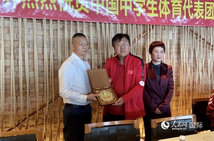 巴西中國和平統(tǒng)一促進(jìn)會會長王俊曉向中國中學(xué)生體育代表團(tuán)團(tuán)長劉立新贈送紀(jì)念品。人民網(wǎng)記者 宋亦然攝