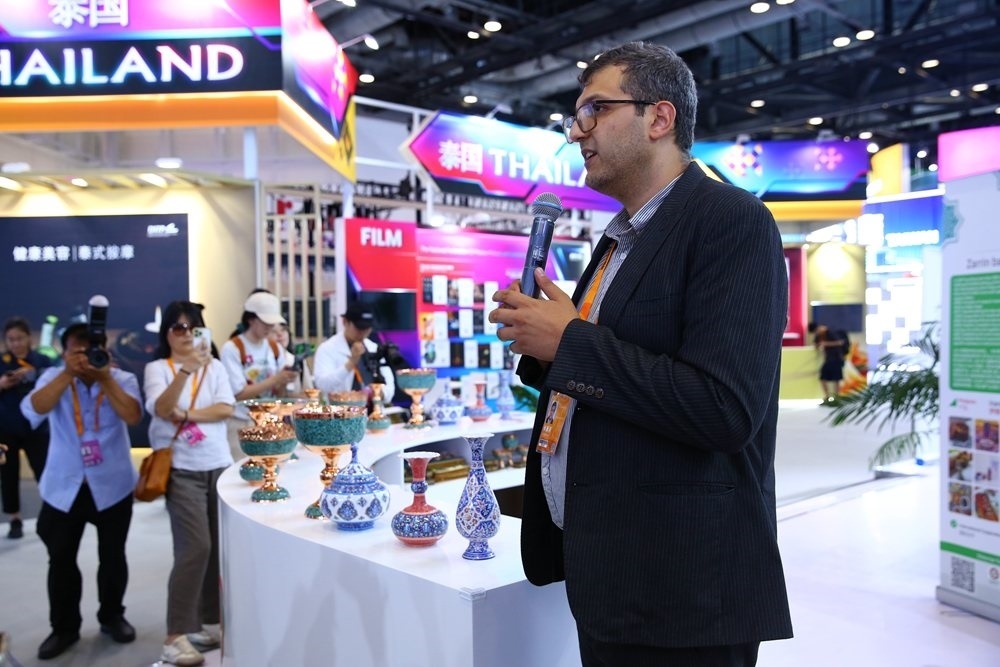 9月1日，參展商在國家會議中心向媒體記者介紹展臺信息。新華社記者 孫瑋彤 攝