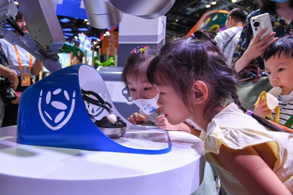 9月3日，幾名小朋友在國家會議中心觀看單孔腔鏡手術機器人展示。新華社記者 鞠煥宗 攝