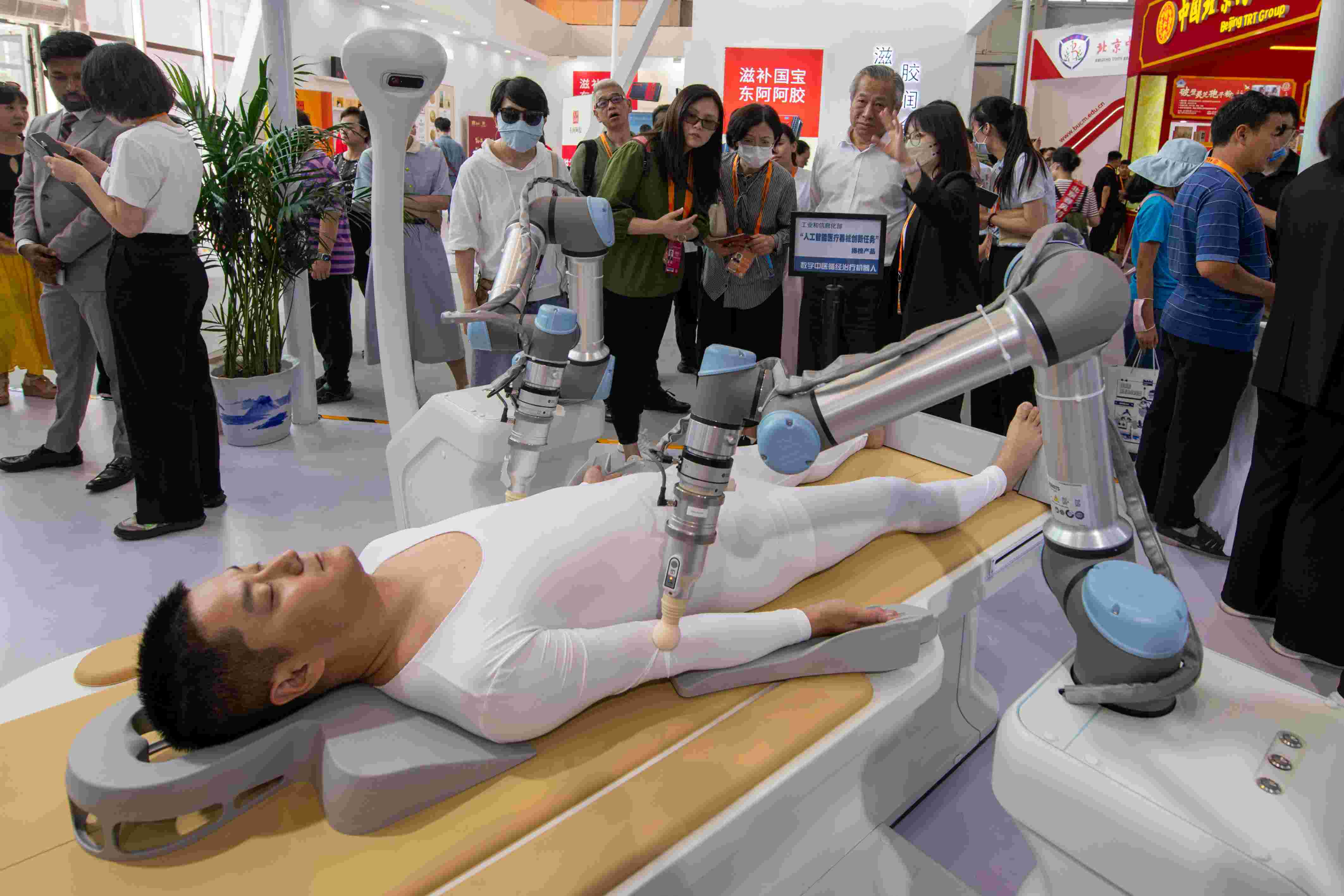 在位于首鋼園的健康衛(wèi)生服務(wù)展區(qū)，觀眾正在參觀數(shù)字中醫(yī)循經(jīng)治療機器人。人民網(wǎng)記者 翁奇羽攝