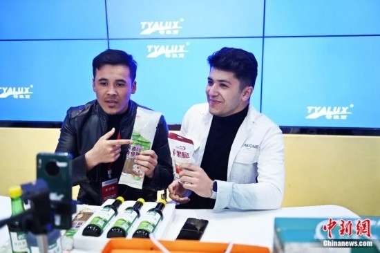 2023年3月，甘肅省慶陽(yáng)市環(huán)縣電商創(chuàng)業(yè)孵化基地內(nèi)，來(lái)自蘭州文理學(xué)院的塔吉克斯坦留學(xué)生正在協(xié)助主播直播帶貨當(dāng)?shù)剞r(nóng)特產(chǎn)品。李亞龍 攝