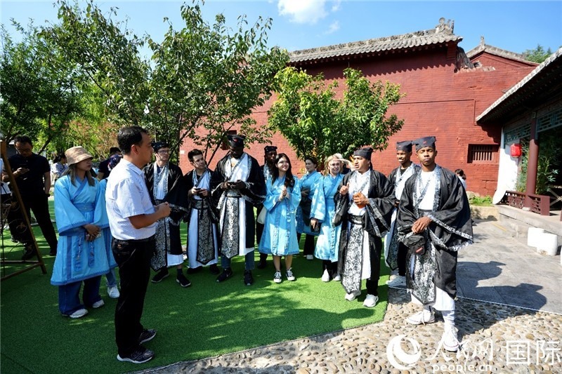 圖為選手們聽(tīng)導(dǎo)游講解。人民網(wǎng) 盧鵬宇攝