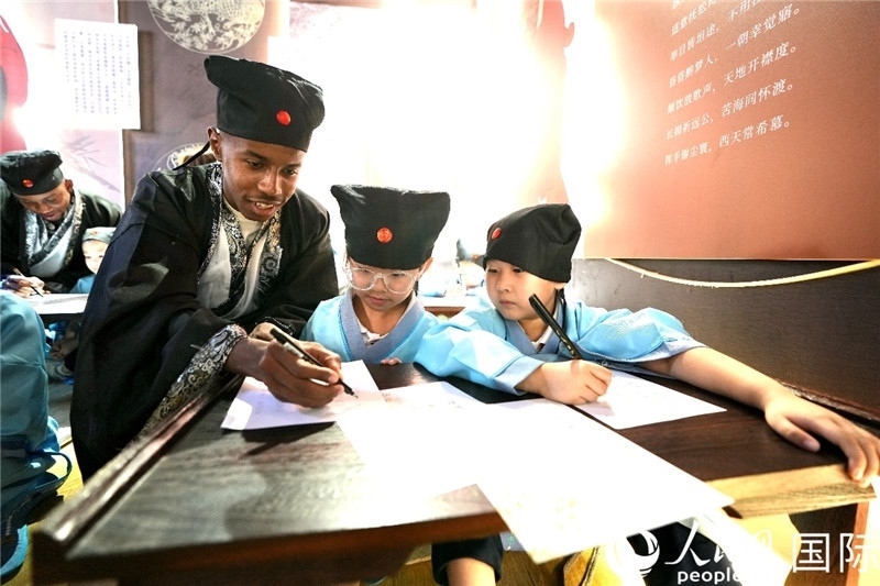 圖為選手與同學(xué)們一起寫(xiě)書(shū)法。人民網(wǎng) 盧鵬宇攝