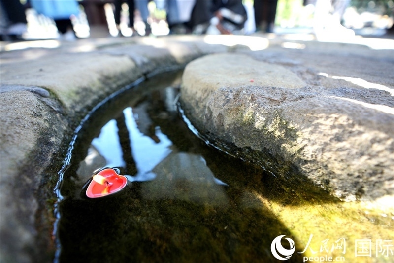 圖為水渠里流過(guò)的“桃心”蠟燭。人民網(wǎng) 盧鵬宇攝
