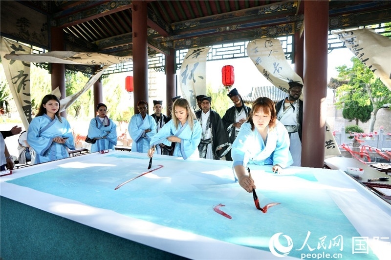 選手們提筆書(shū)寫(xiě)“家園”二字。人民網(wǎng) 盧鵬宇攝