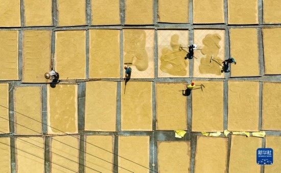 9月16日，在湖南省懷化市通道侗族自治縣萬(wàn)佛山鎮(zhèn)溪上村，村民在晾曬稻谷（無(wú)人機(jī)照片）。