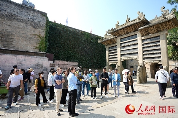 選手們認(rèn)真聆聽導(dǎo)游講解。人民網(wǎng) 盧鵬宇攝