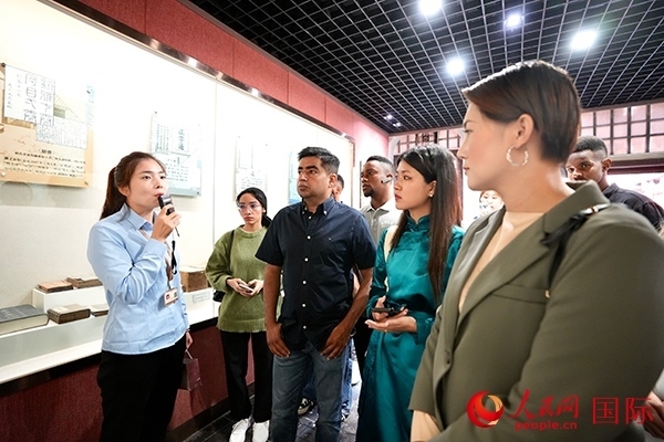 選手們認(rèn)真聆聽導(dǎo)游講解。人民網(wǎng) 盧鵬宇攝