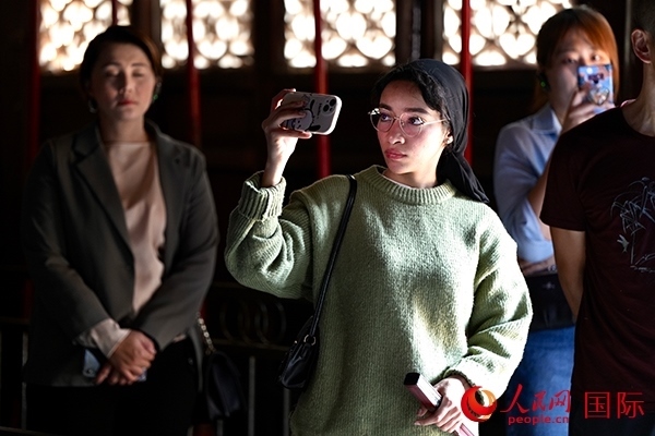 選手顏青（蘇丹）用手機(jī)記錄所見所感。人民網(wǎng) 盧鵬宇攝