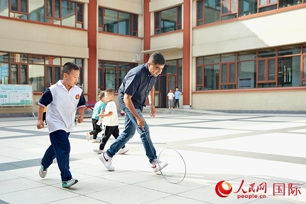 來(lái)自巴基斯坦的沙杰在滾鐵環(huán)。人民網(wǎng) 盧鵬宇攝