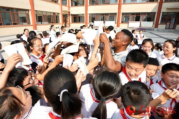 孩子們和選手互動(dòng)簽名。人民網(wǎng) 盧鵬宇攝