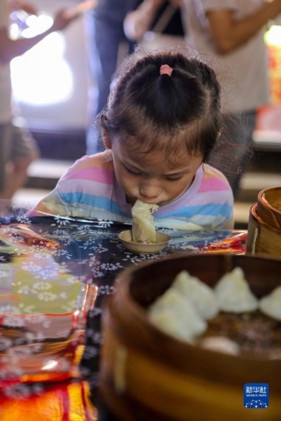 9月27日，小朋友在南翔小籠長街宴上品嘗南翔小籠。