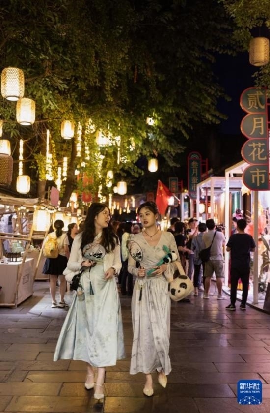 在成都寬窄巷子，兩位來(lái)自安徽的游客在新“十二月市”街區(qū)游覽（9月29日攝）。