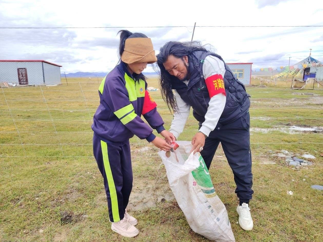 玉樹州稱多縣珍秦鎮(zhèn)河湖志愿者才培和他女兒更求拉毛在清掃垃圾。受訪者供圖