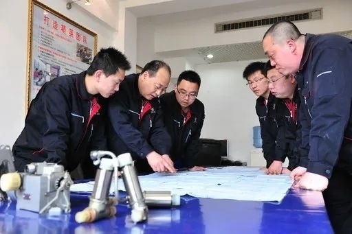 △李志強(qiáng)（左二）與班組成員在研究工作。