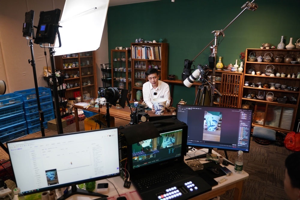 ↑在景德鎮(zhèn)，工作人員通過(guò)網(wǎng)絡(luò)直播推介陶瓷產(chǎn)品（2023年2月22日攝）。