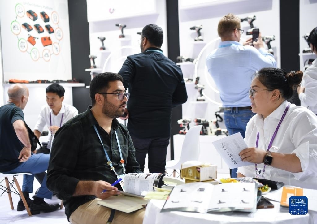 10月15日，在一家電動工具展臺，外國采購商在洽談業(yè)務(wù)。新華社記者 鄧華 攝